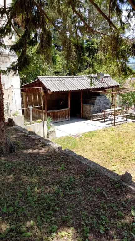 a building in a field with a tree at JAJCE Historic House in Jajce