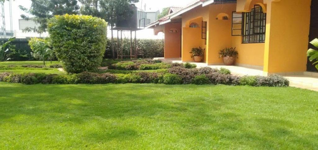 a house with a yard with green grass at Majimbo Whitehouse Resort in Ramogi