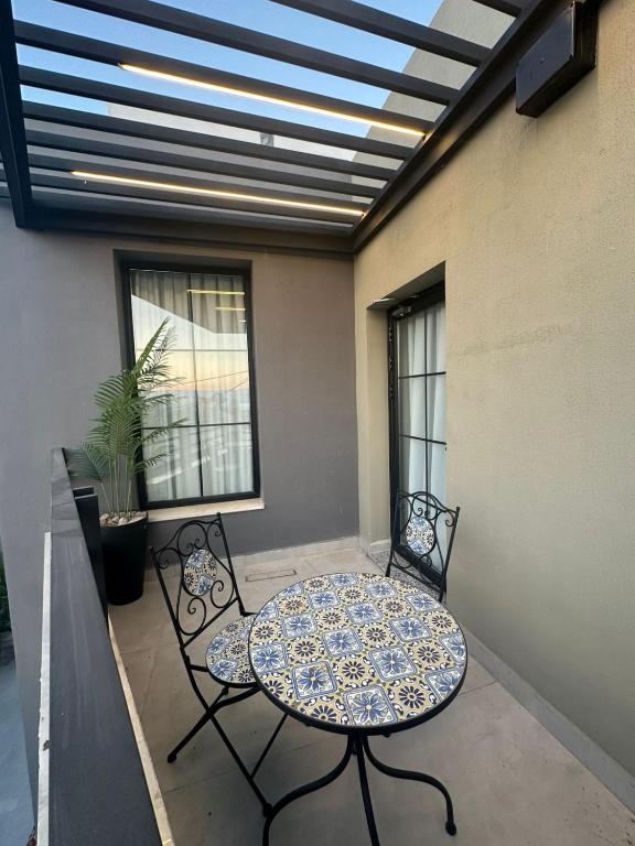 a patio with a table and chairs on a balcony at Trio Luxury Apartment 3 in Sowayma