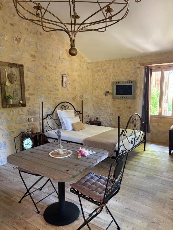 a bedroom with a bed and a table in a room at Douce escapade in Bourg-Saint-Andéol