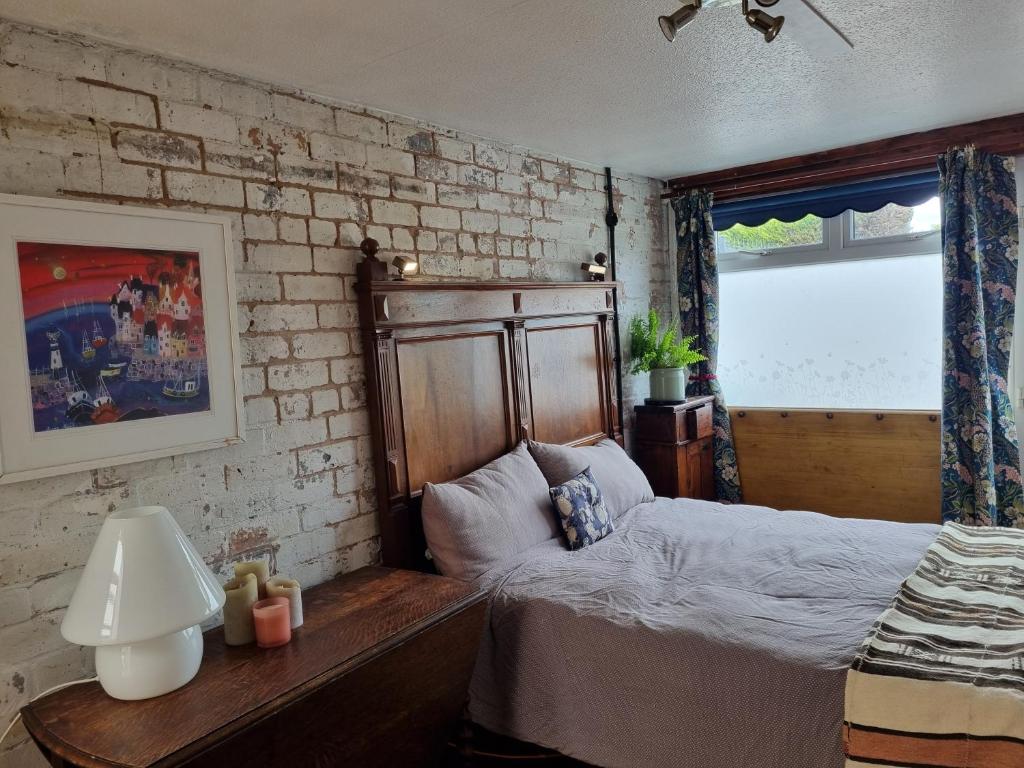 a bedroom with a bed and a brick wall at Room at Lindley in Ludlow