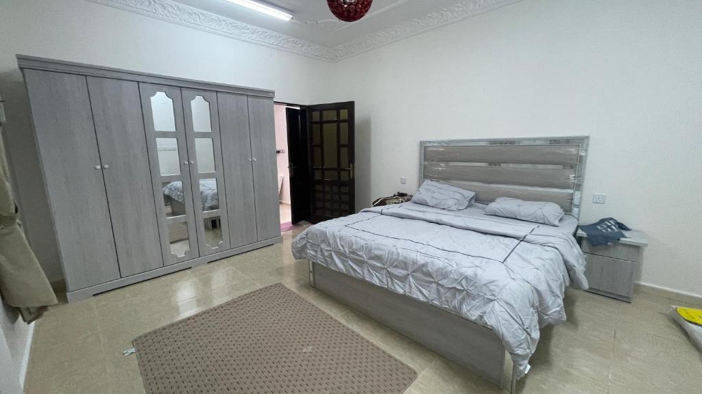 a bedroom with a bed in a white room at شقق مفروشة الطارق in Ḩaql