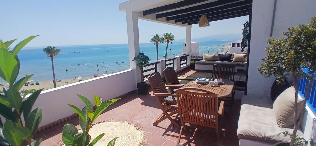 a patio with a table and chairs and the beach at Espectacular dúplex a pie de mar in Cabo Negro