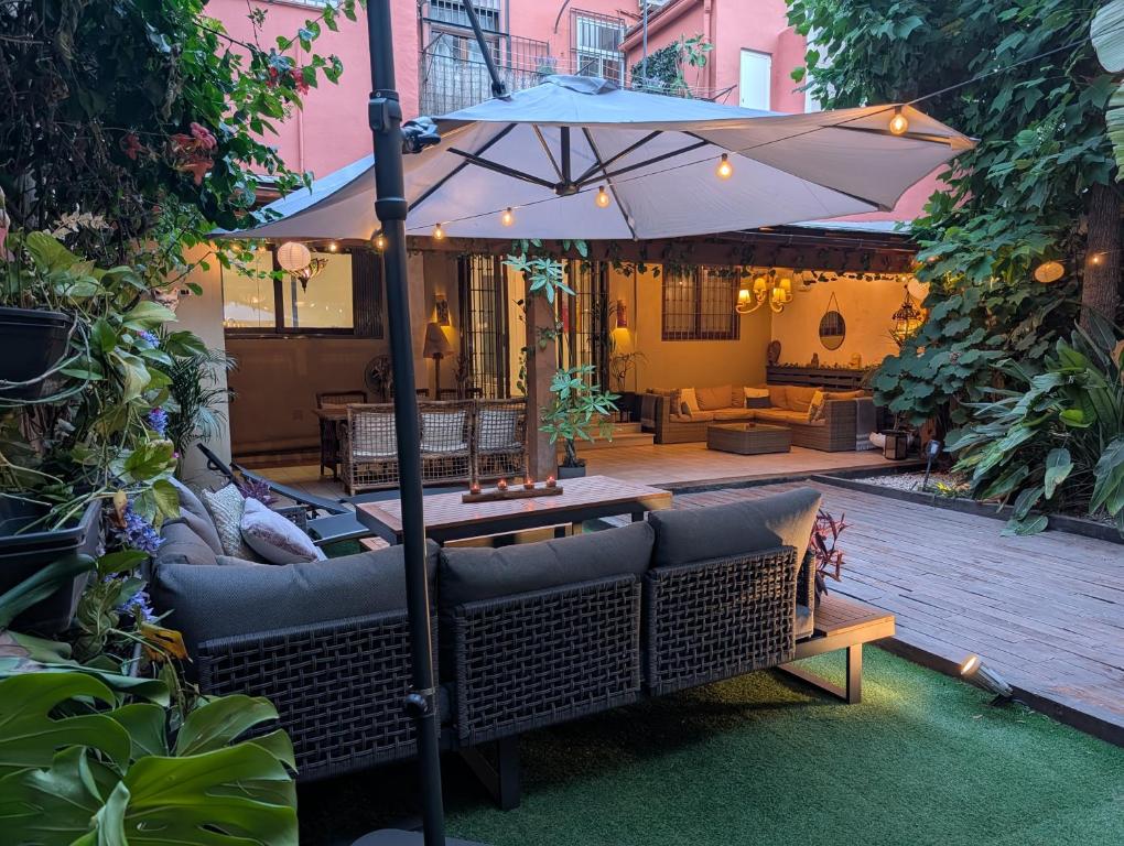 a patio with a table and an umbrella at Portrait Boutique Villa in Valencia