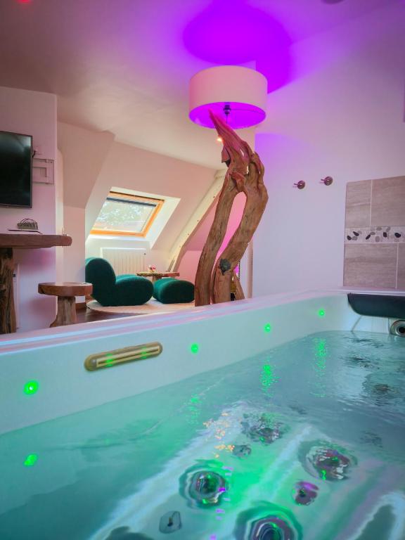 a tub with a tree in the middle of a room at Domaine de la Besnerie Gites avec SPA Privatif à 10 min du Mont St Michel in Tanis