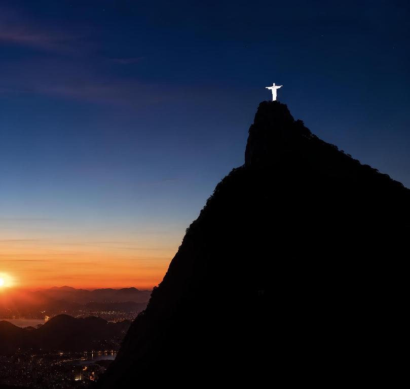 a christ the redeemer on top of a mountain at sunset at Panorama Inn in Rio de Janeiro