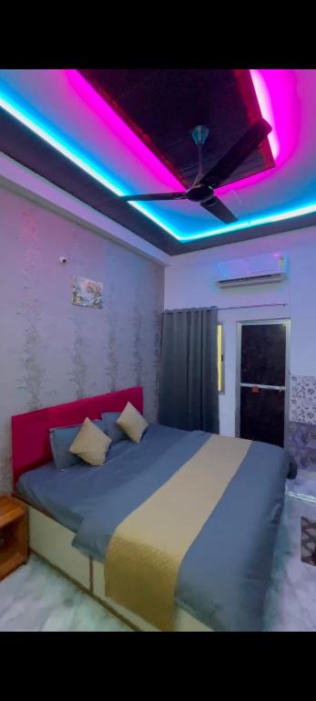 a bedroom with a bed with purple lights on it at Hotel Vanilla inn sarkanda in Bilāspur