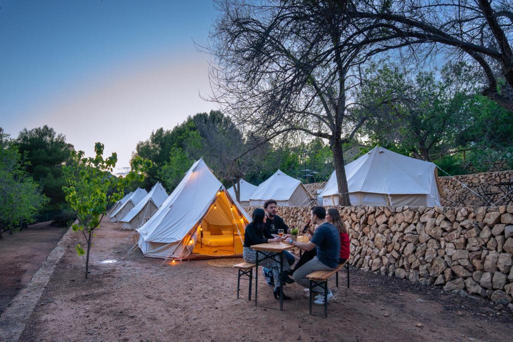 a group of people sitting at a table in front of tents at Kampaoh Fonts d' Algar in Callosa d'en Sarrià
