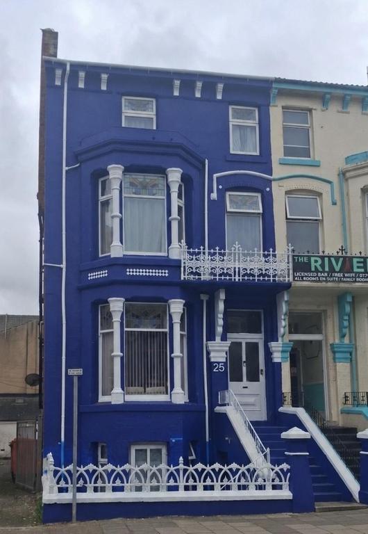 a blue house with a white balcony on a street at Stay at 25 in Blackpool