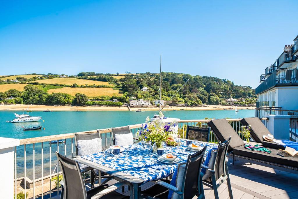 a table on a balcony with a view of the water at No 21 The Salcombe in Salcombe