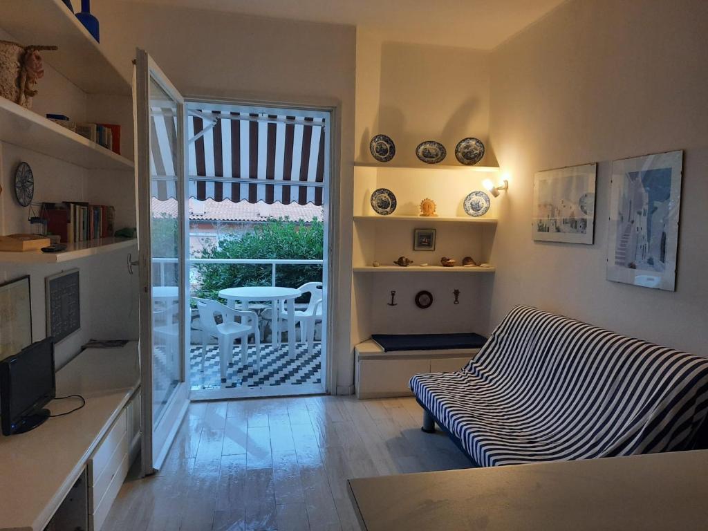 a living room with a couch and a sliding glass door at Grazioso monolocale Isola d'Elba in Capo D'Arco