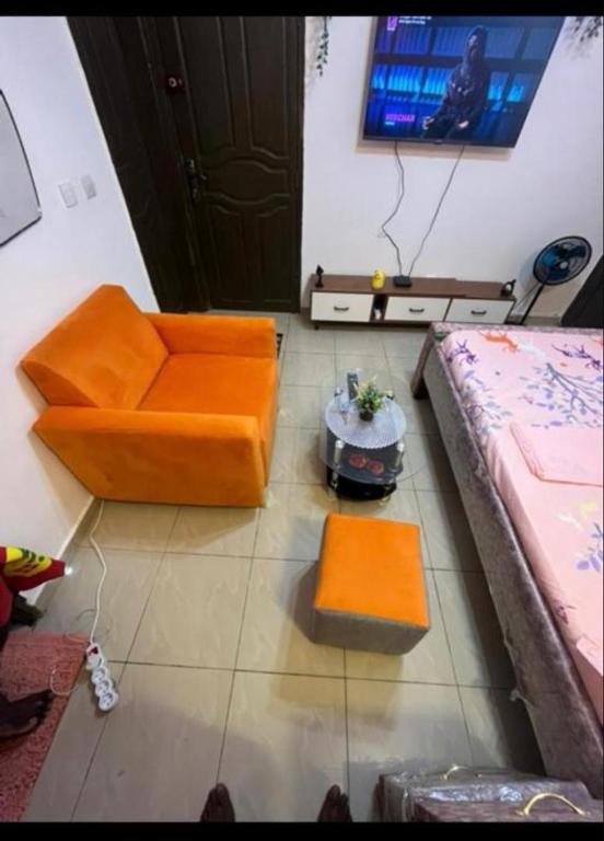 a living room with orange furniture and a tv at Résidence kone daouda in Abidjan