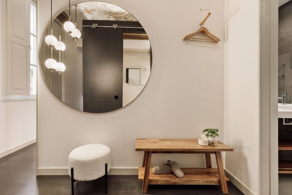 a bathroom with a round mirror and a table at Ola Living Portaferrissa in Barcelona