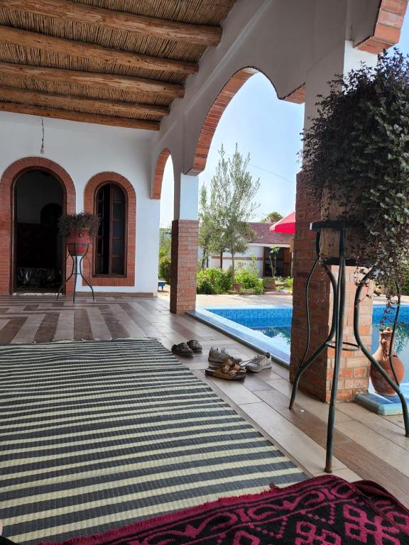 a house with a swimming pool and a patio with a rug at Séjour Traditionelle in Oulad Teïma