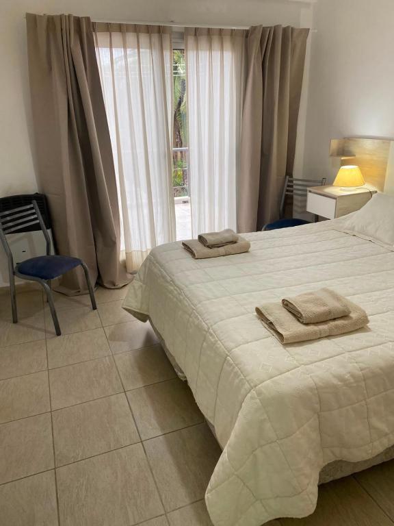 a bedroom with a large bed with towels on it at Heart Viedma in Viedma