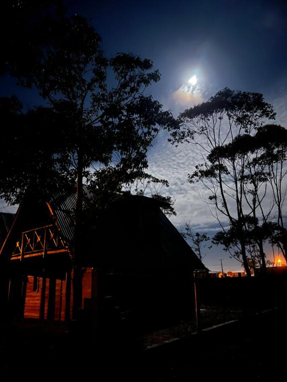 a night view of a barn with the moon in the sky at Cabanas Brisa da Lagoa in Arroio do Silva