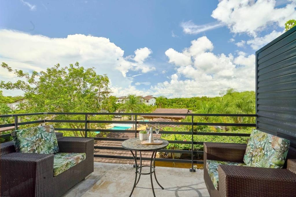 a patio with two chairs and a table on a balcony at Hideaway in Paradise in Juan Dolio
