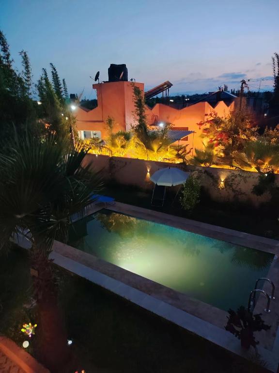 a swimming pool in a yard at night at FERME Mama Aïcha in Kenitra