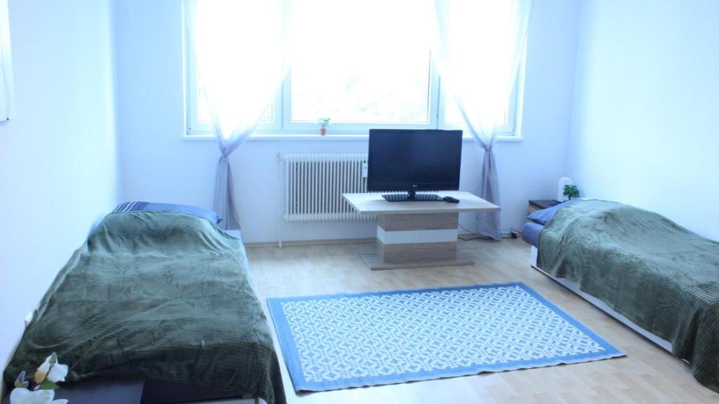 a living room with two beds and a television at 35 Square meter Apartment in Sankt Pölten