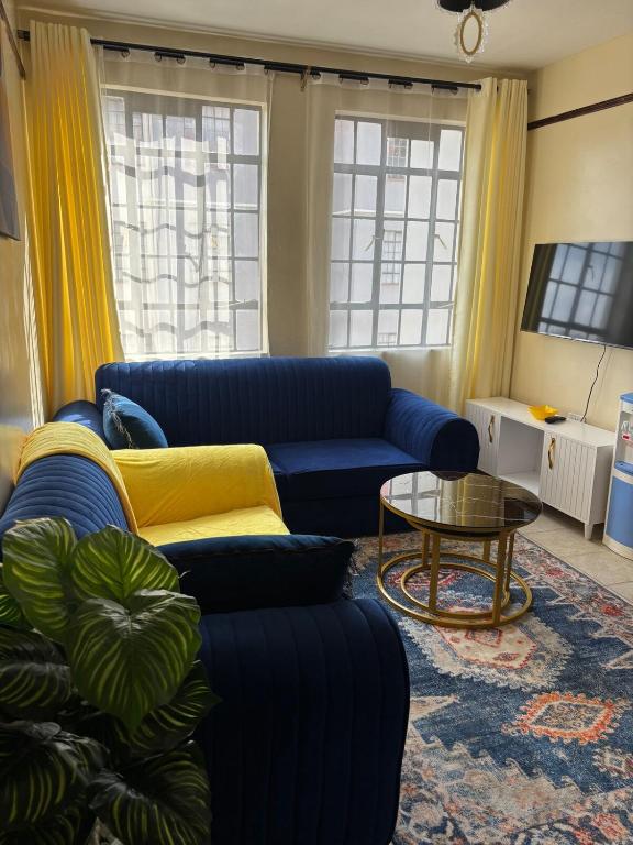 a living room with two blue couches and a table at Prestige apartments Machakos in Machakos