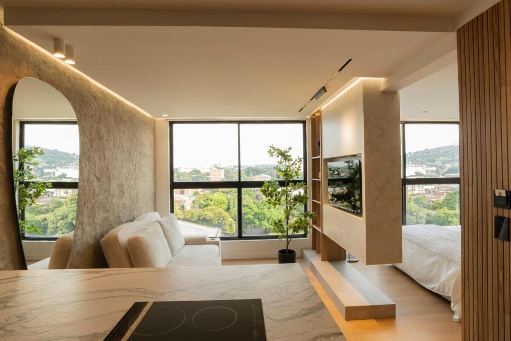 a bedroom with a bed and large windows at Modern, Fully Equipped and Cozy Loft in Cali
