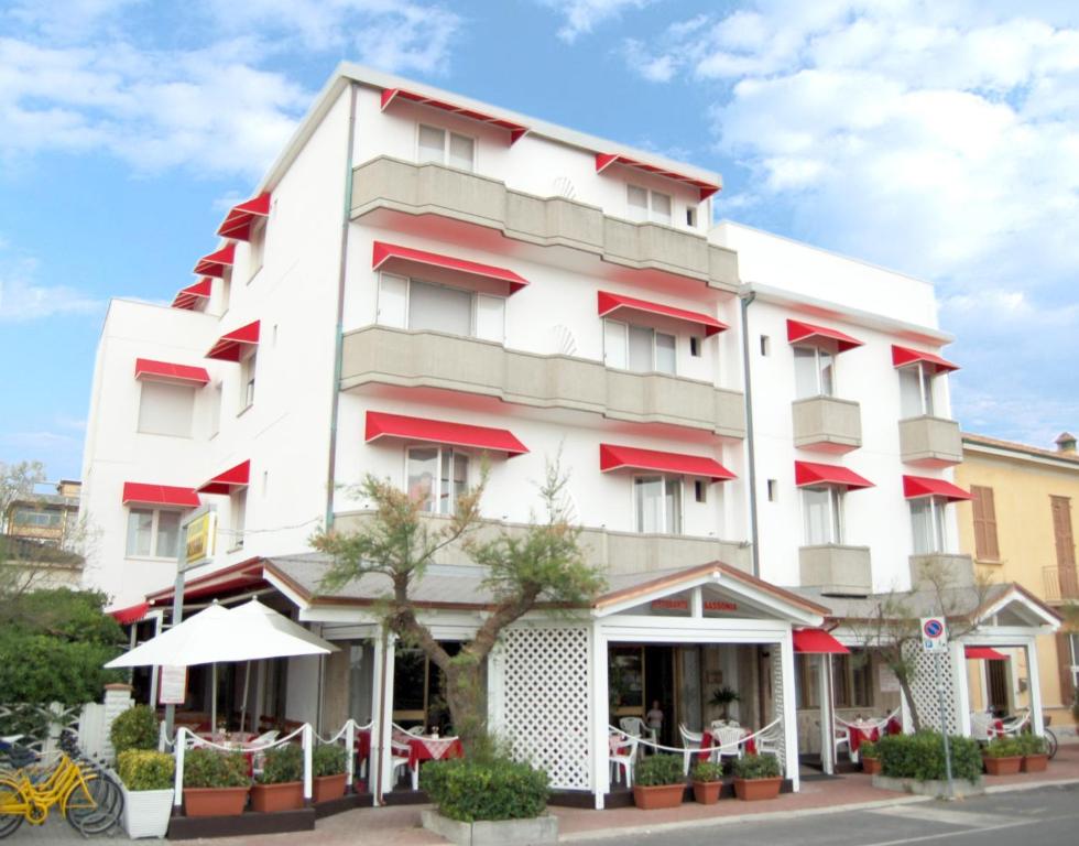 ein großes weißes Gebäude mit roten Akzenten in der Unterkunft Hotel Sassonia in Fano