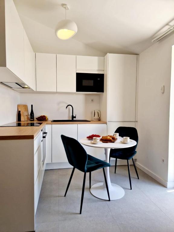 a kitchen with a table and chairs in a kitchen at Dizma Welness Apartmani in Duće
