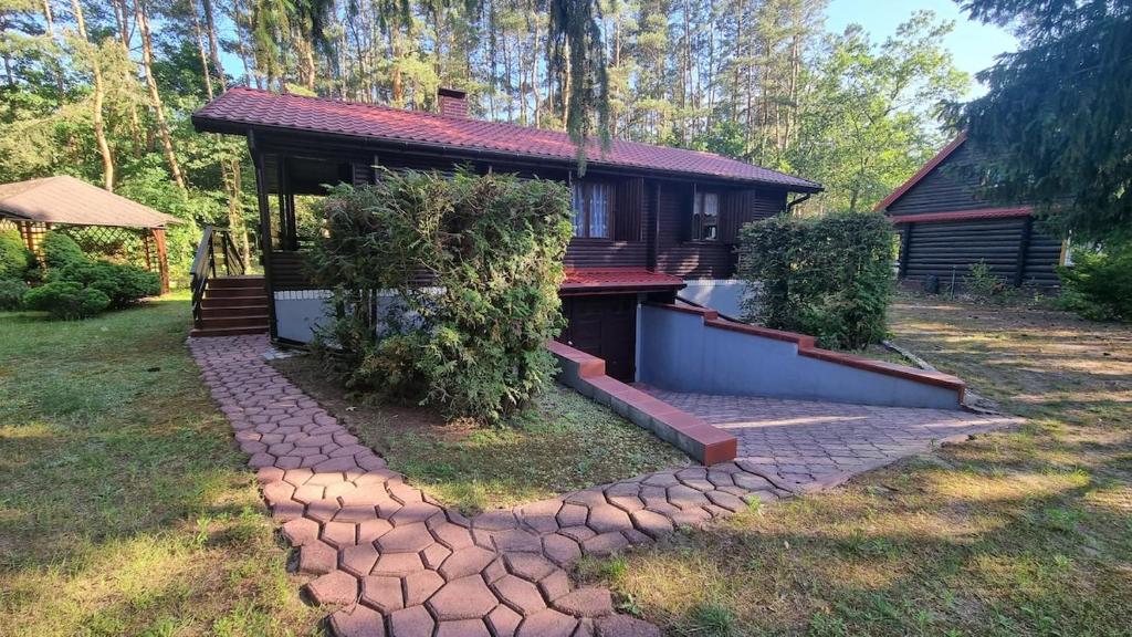 a house with a stone path in front of it at Domek Szumin-Wywłoka in Majdan