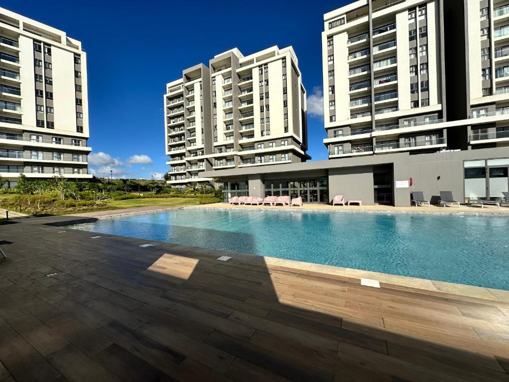 a swimming pool in the middle of two tall buildings at Haven Suites in Moka