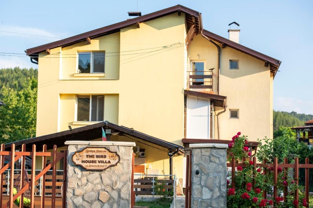 a house with a sign in front of it at The Bird Villa in Bosnek