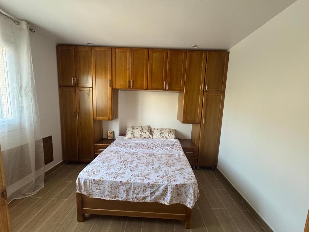a bedroom with a bed and wooden cabinets at Belle appart in Aguemoun Taïda