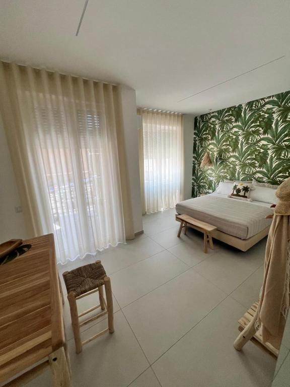 a bedroom with a bed and a green and white wallpaper at Mamma mia rooms in Nola
