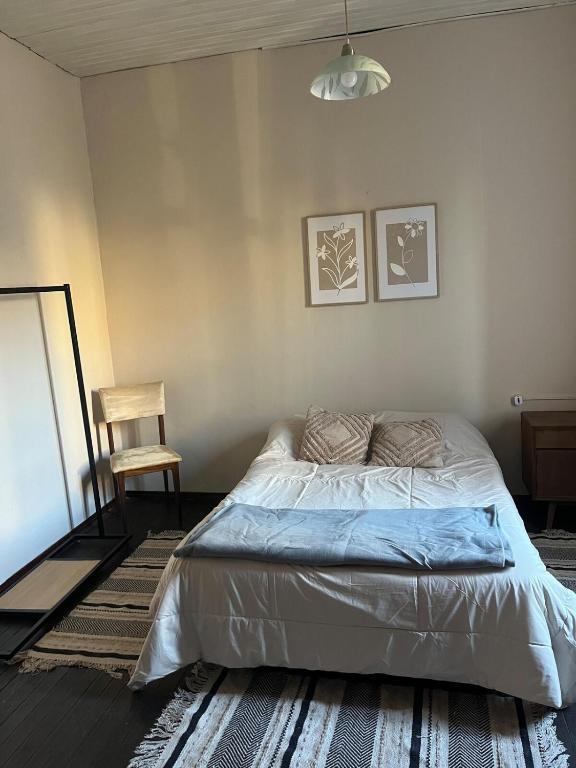 a bedroom with a bed and a chair in it at disfruta tu estadía in Salto