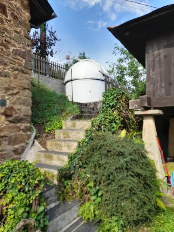 a set of stairs leading up to a building with a tank at Vega in Muñás