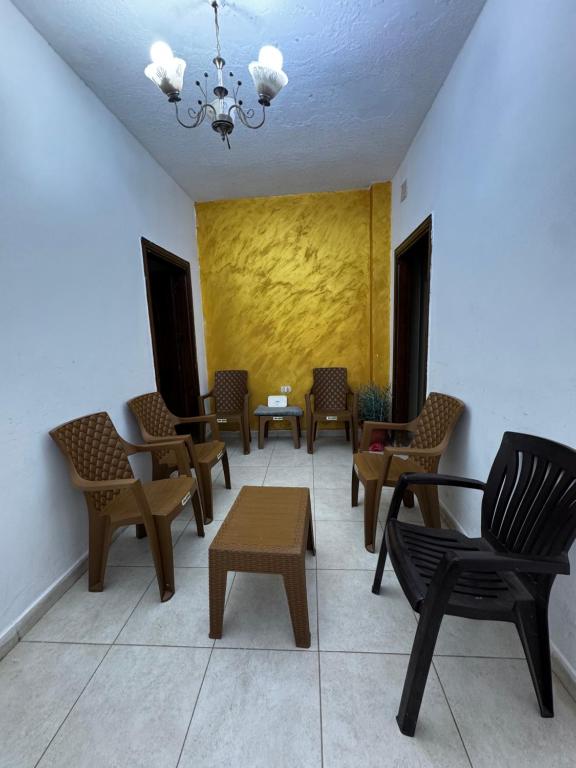 a waiting room with chairs and tables and a chandelier at جرش in Dayr al Līyāt