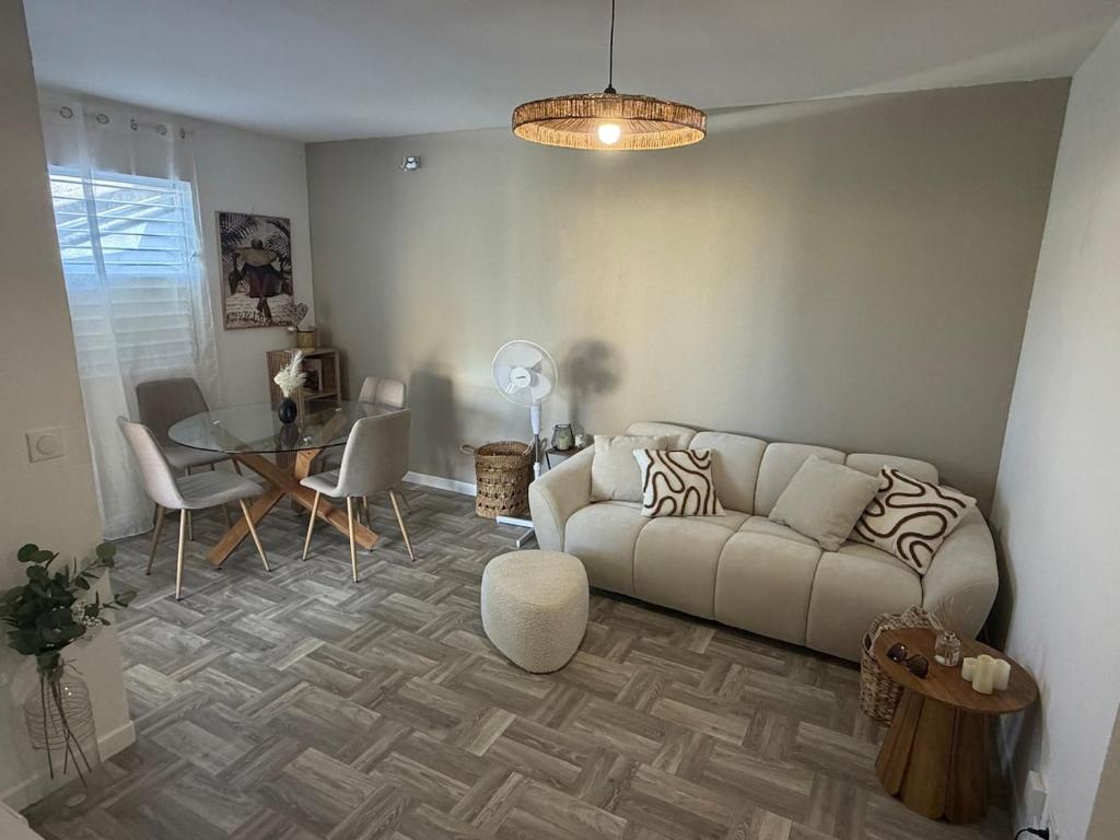 a living room with a couch and a table at Appartement Kazalya in Sainte-Rose