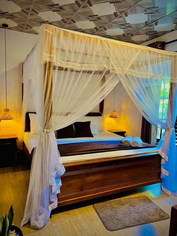 a bedroom with a canopy bed with mosquito nets at LEAFORA Cottage in Galle
