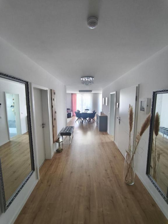an empty living room with white walls and wooden floors at Zeitlos in Stutensee