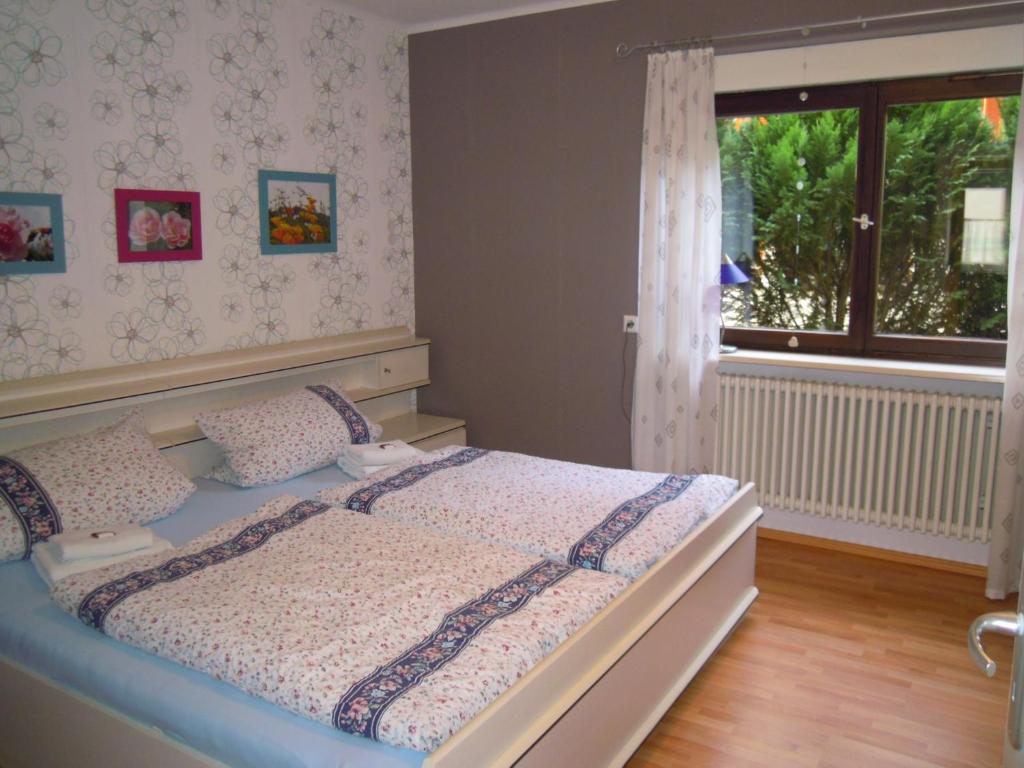 Schlafzimmer mit einem Bett und einem Fenster in der Unterkunft Ferienwohnung Haller in Lahr