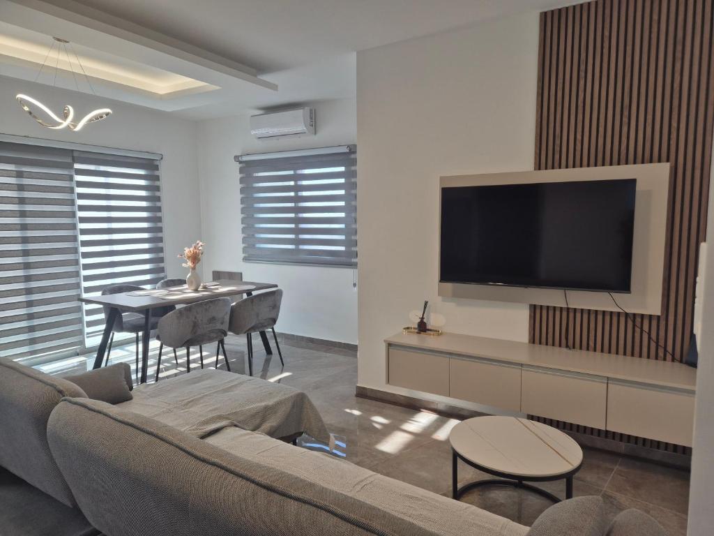 a living room with a couch and a flat screen tv at AK Appartment in Kato Pyrgos