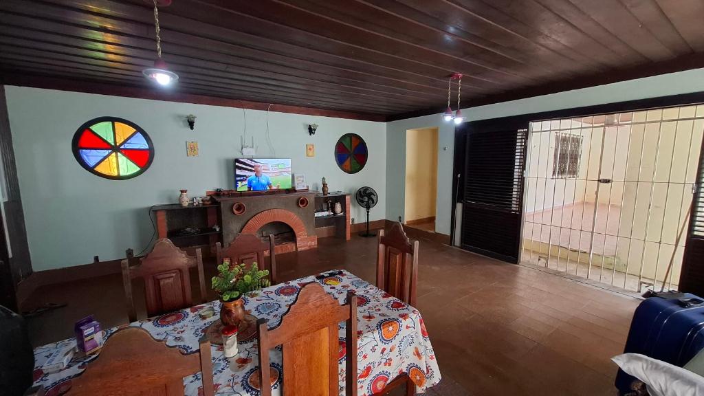 a living room with a table and a dining room at Moka Refúgium-Casa de praia aconchegante e espaçosa in Belém