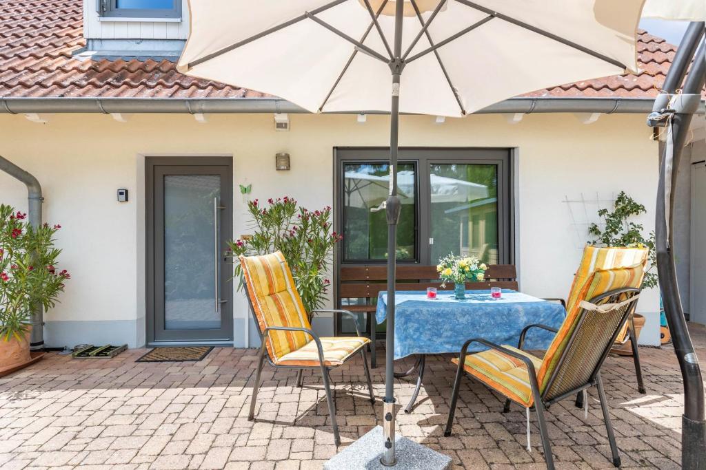 ein Tisch und Stühle mit einem Sonnenschirm auf einer Terrasse in der Unterkunft Seeperle in Moos