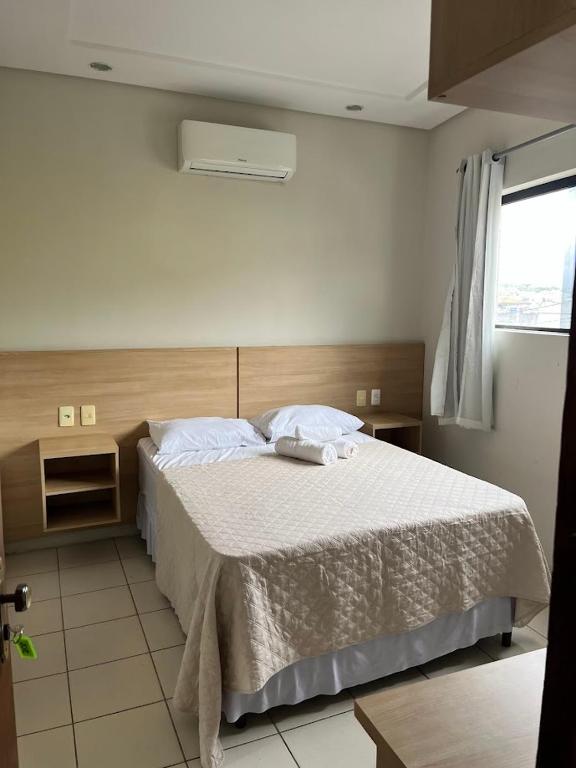 a bedroom with a large bed with white sheets at Hotel Piracema Caruaru in Caruaru