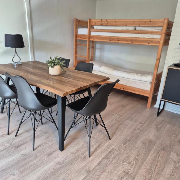 a dining room with a table and chairs and a bunk bed at Feriehuse Hvide Sande in Hvide Sande