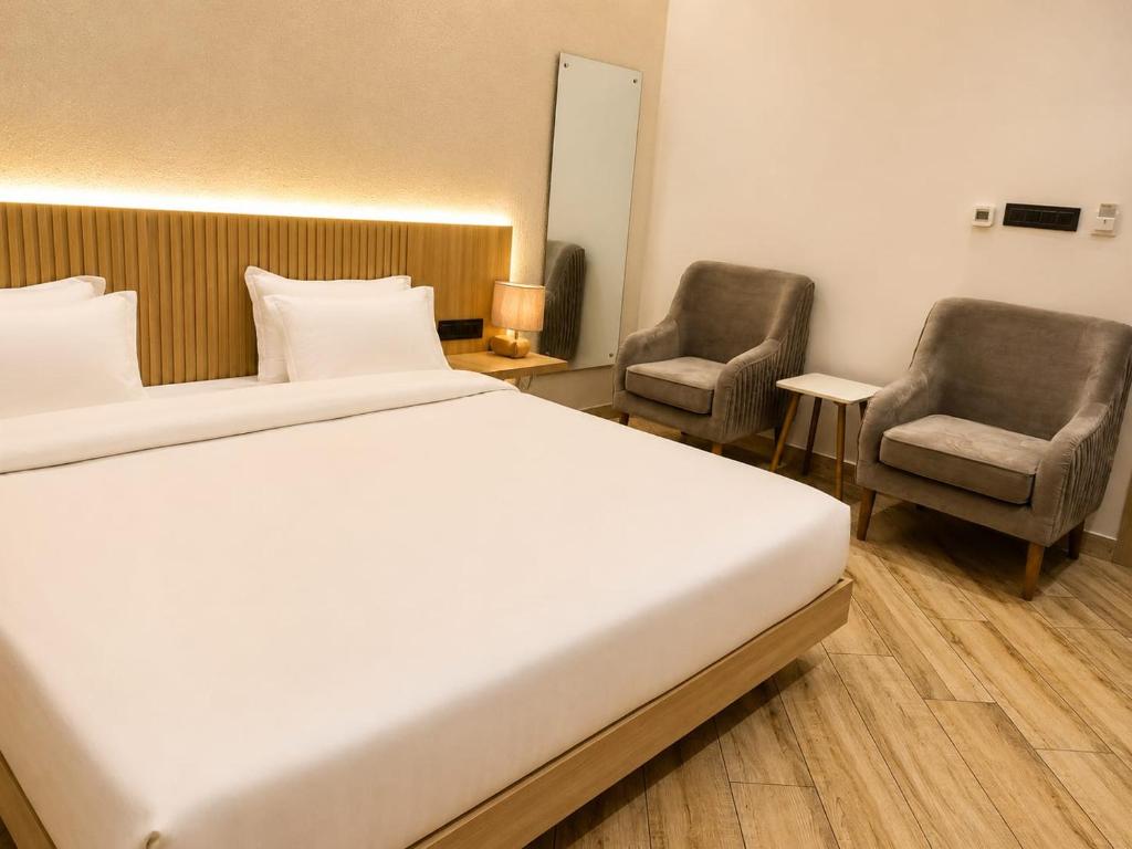 a hotel room with a bed and two chairs at The Sky Deck in Haldwāni