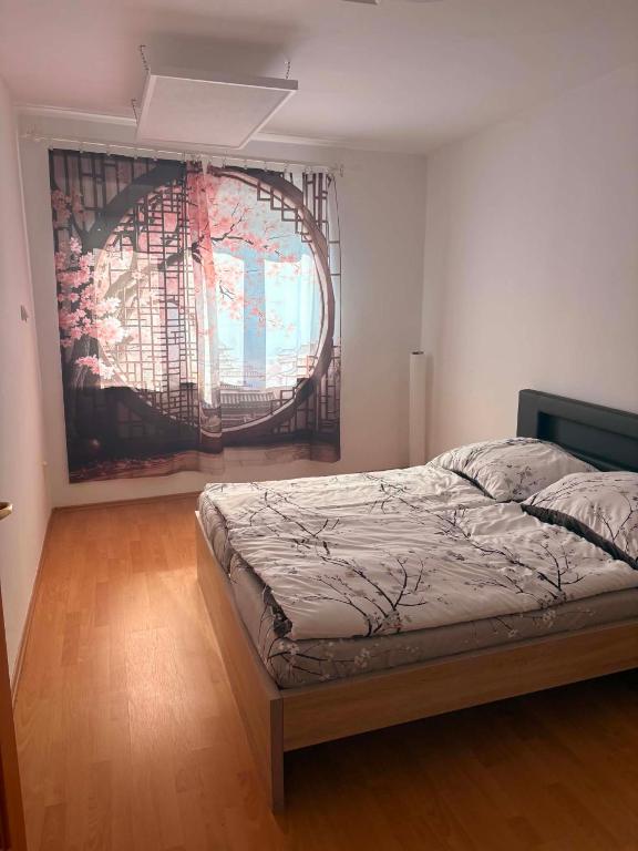 a bedroom with a bed and a large painting on the wall at sakura-spa Jesenice in Rakovník
