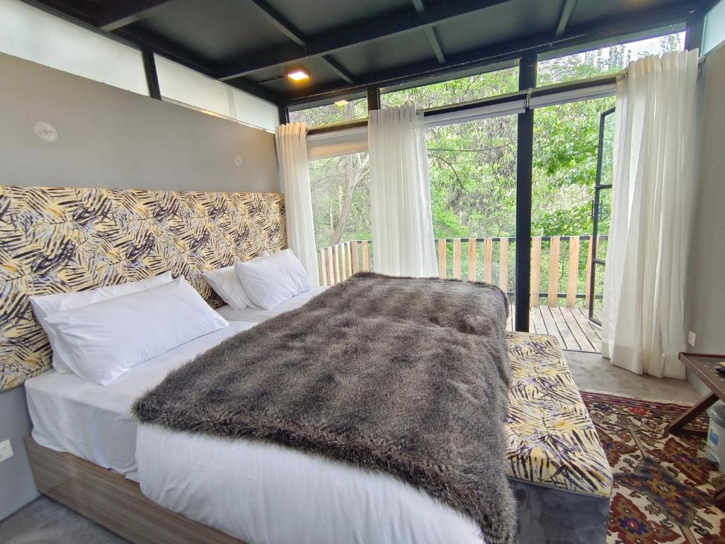 a bedroom with a bed and a large window at Cloud Nine And A Half in Hunza Valley