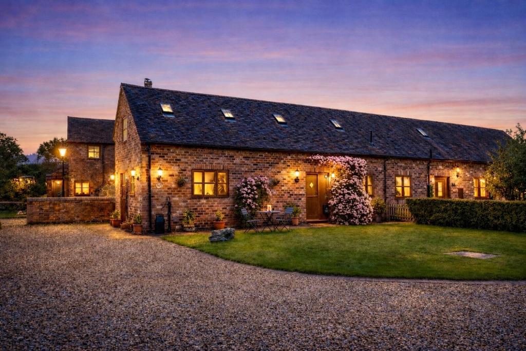 a stone house with a dark roof at The Pigsty - 3 Bedroom Barn Conversion in Coventry