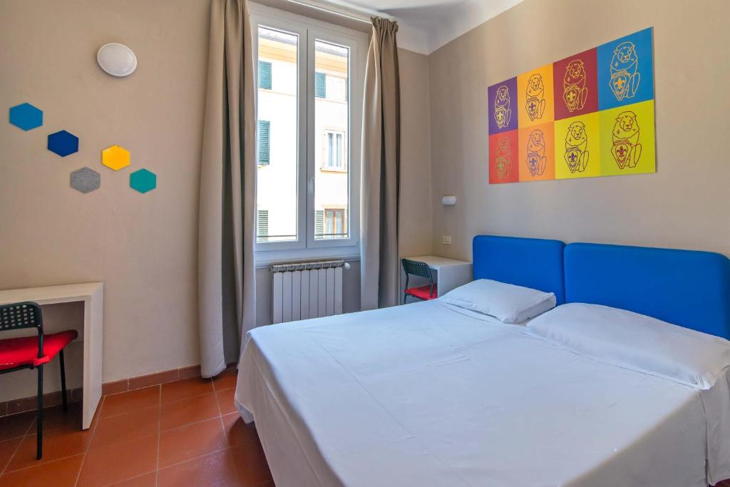 een slaapkamer met een blauw bed en een raam bij Hotel Genesi in Florence