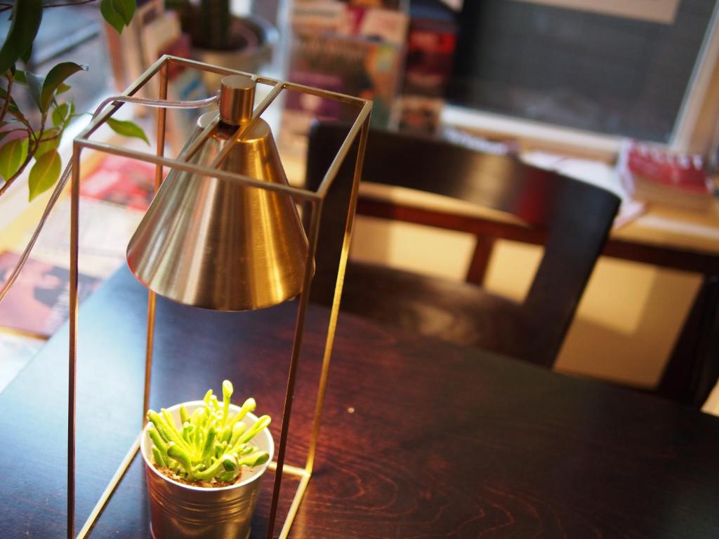 une table avec une lampe et une plante en pot sur celle-ci, dans l'établissement Hotel Carillon, à Haarlem